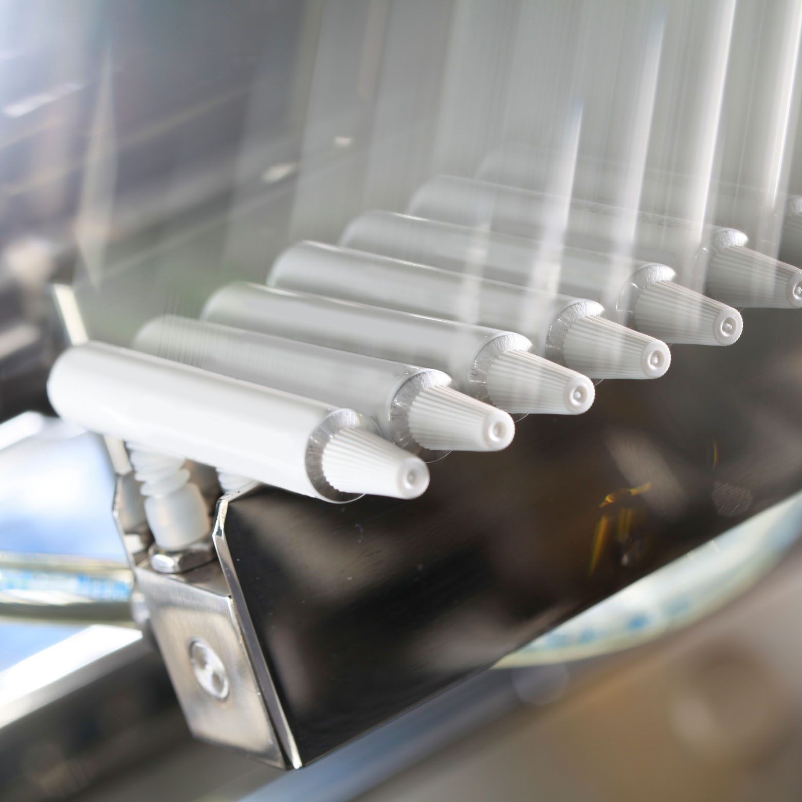 Schnelllaufaufnahme einer aseptischen Dosierstation mit mehreren weißen Tuben.