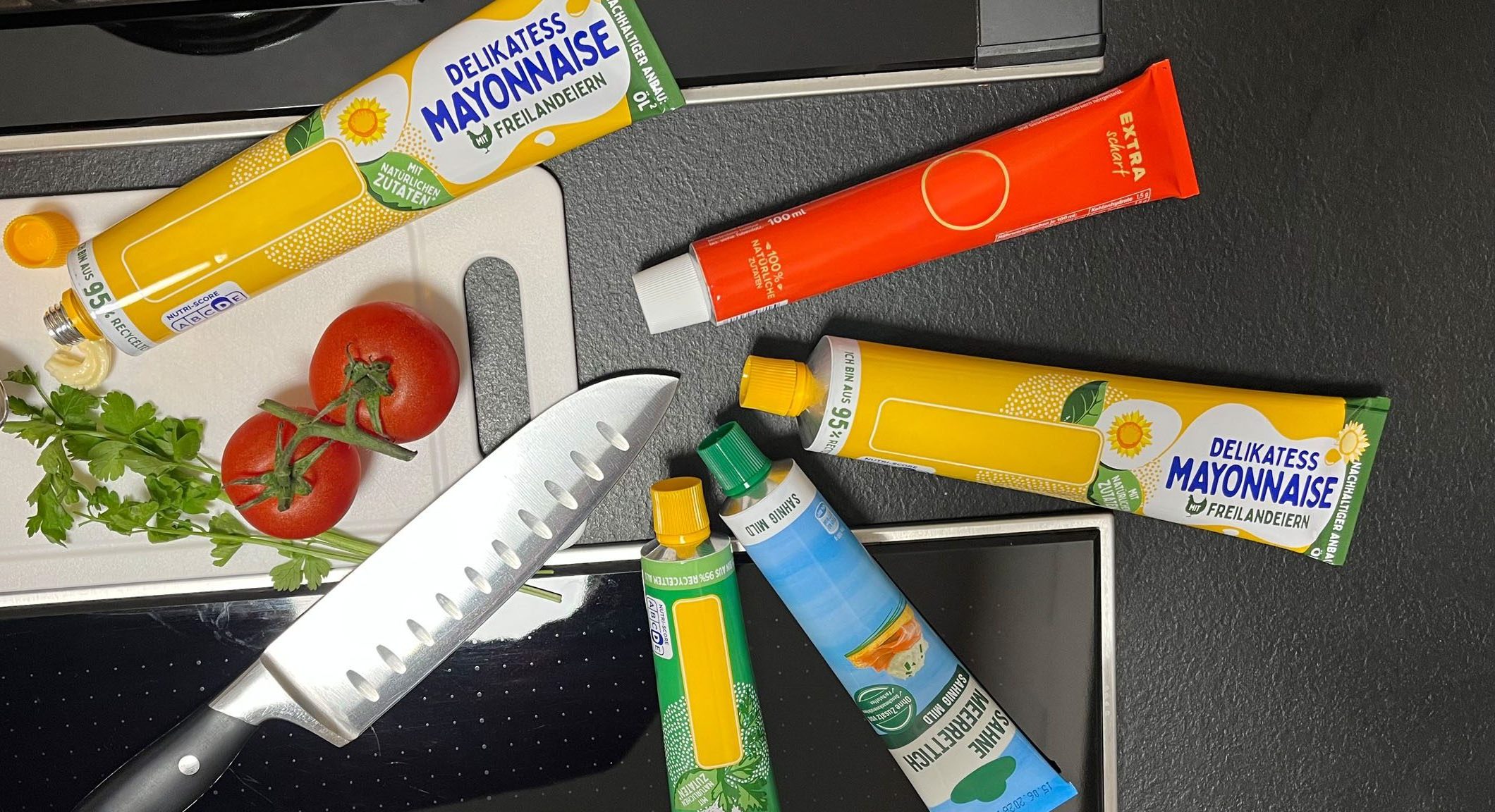 Lebensmittelprodukte in verschiedenen Tubenverpackungen auf einer Küchenfläche.