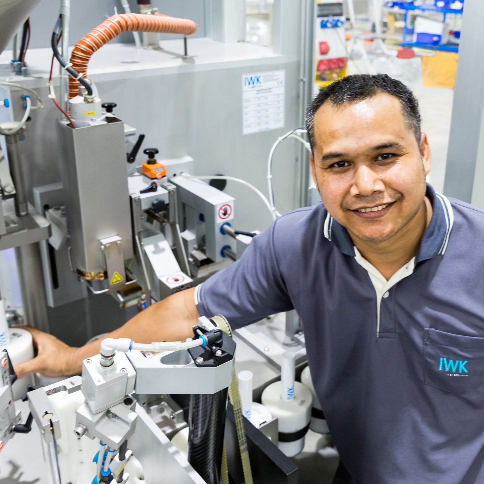 Technische Fachkraft arbeitet an einer pharmazeutischen Abfüllanlage mit präzisen Maschinenkomponenten.