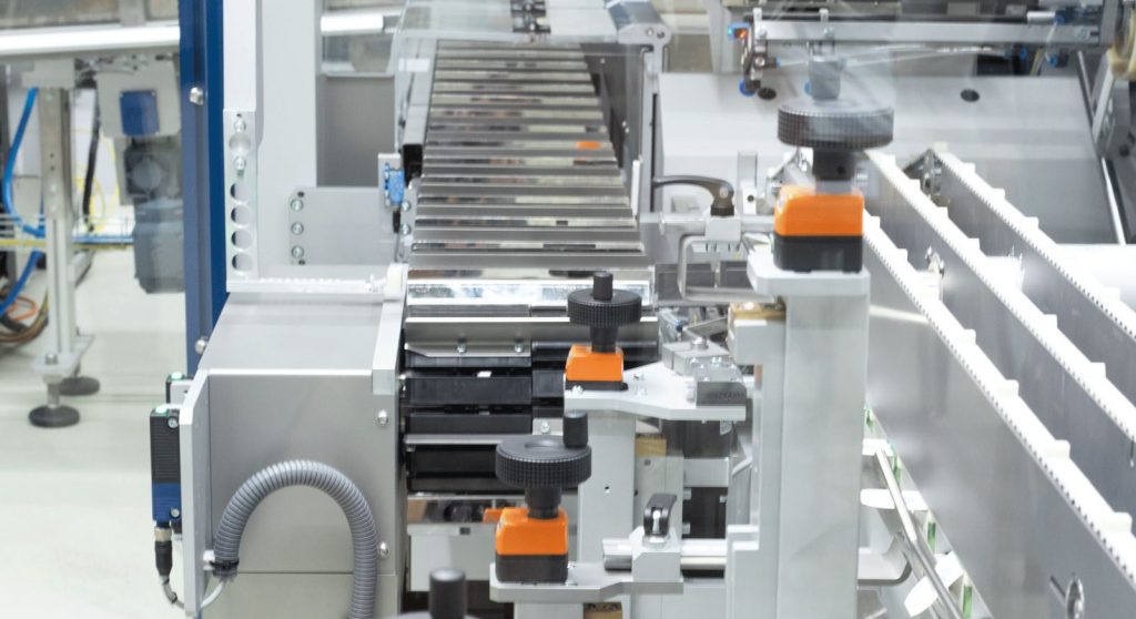 CH4 Kartonierer in Produktionsumgebung mit klarer Linienführung und Schutzverglasung.