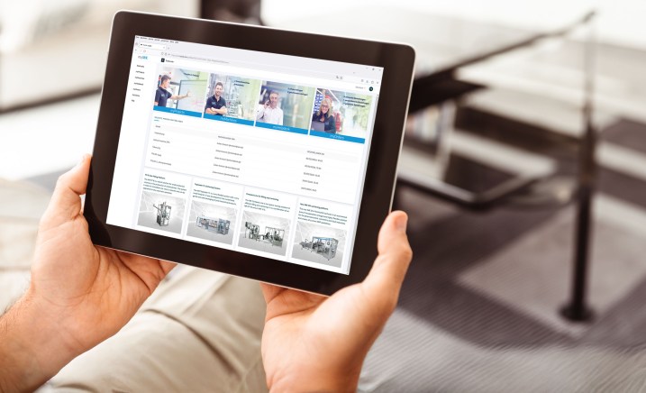 Person holding a tablet with an IWK digital service interface to display machine information.