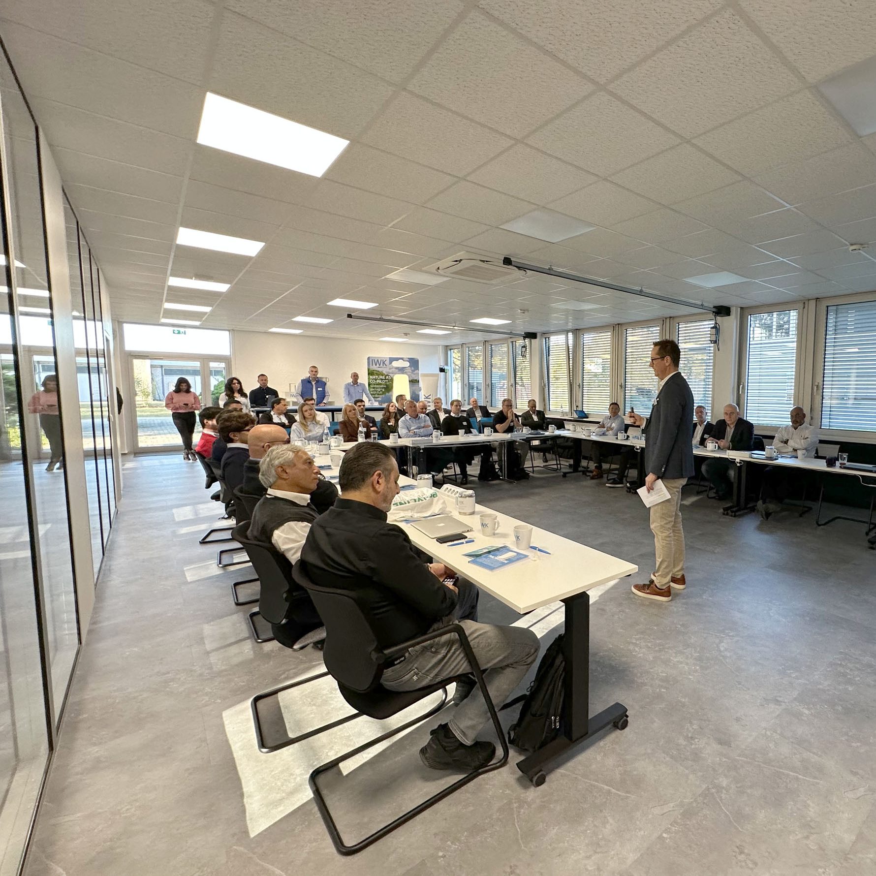Meeting room with many participants following a presentation.