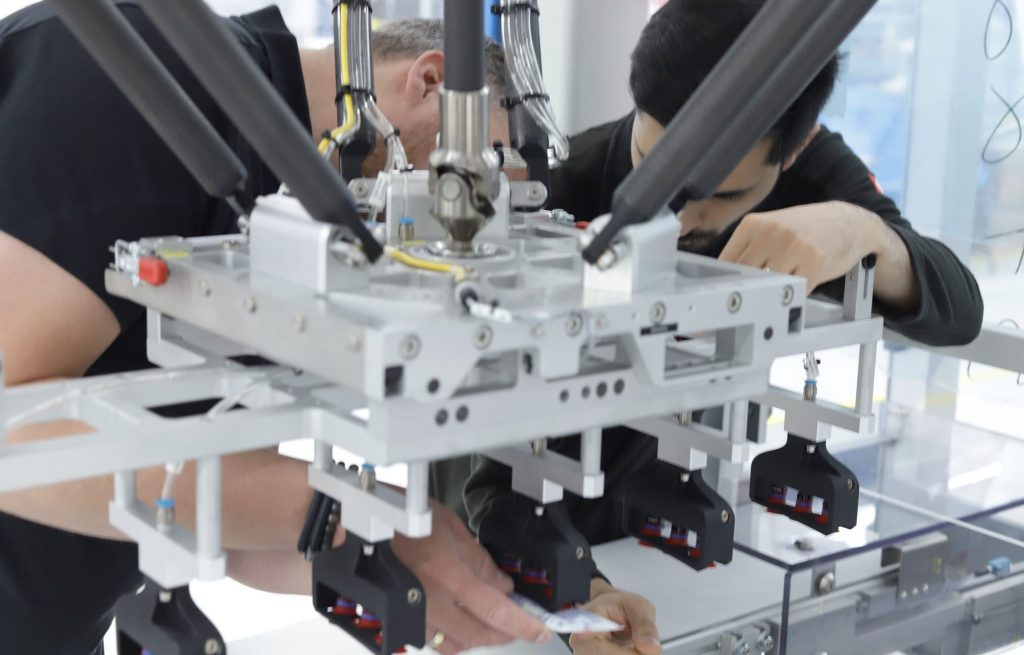 Technische Arbeit unter einem robotergestützten Greifsystem mit mehreren Greifmodulen.