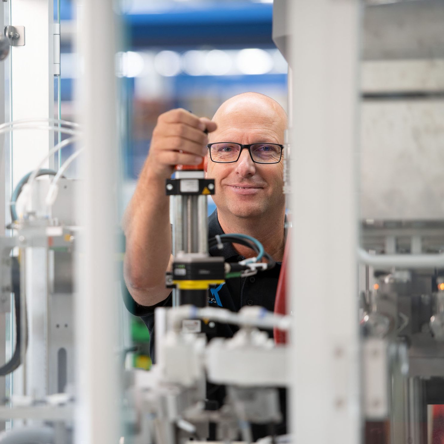 Technical specialist sets up a mechanical module of a tube filling machine.