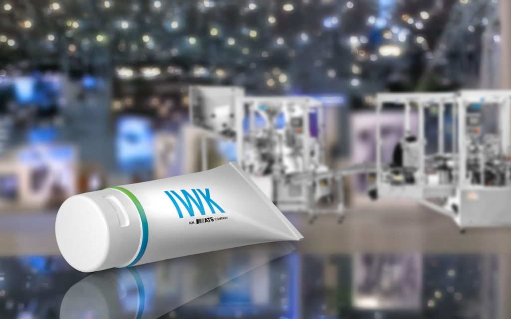 IWK Tube auf reflektierender Fläche vor einer modernen Verpackungsmaschine.