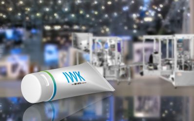 IWK Tube on reflective surface in front of a modern packaging machine.