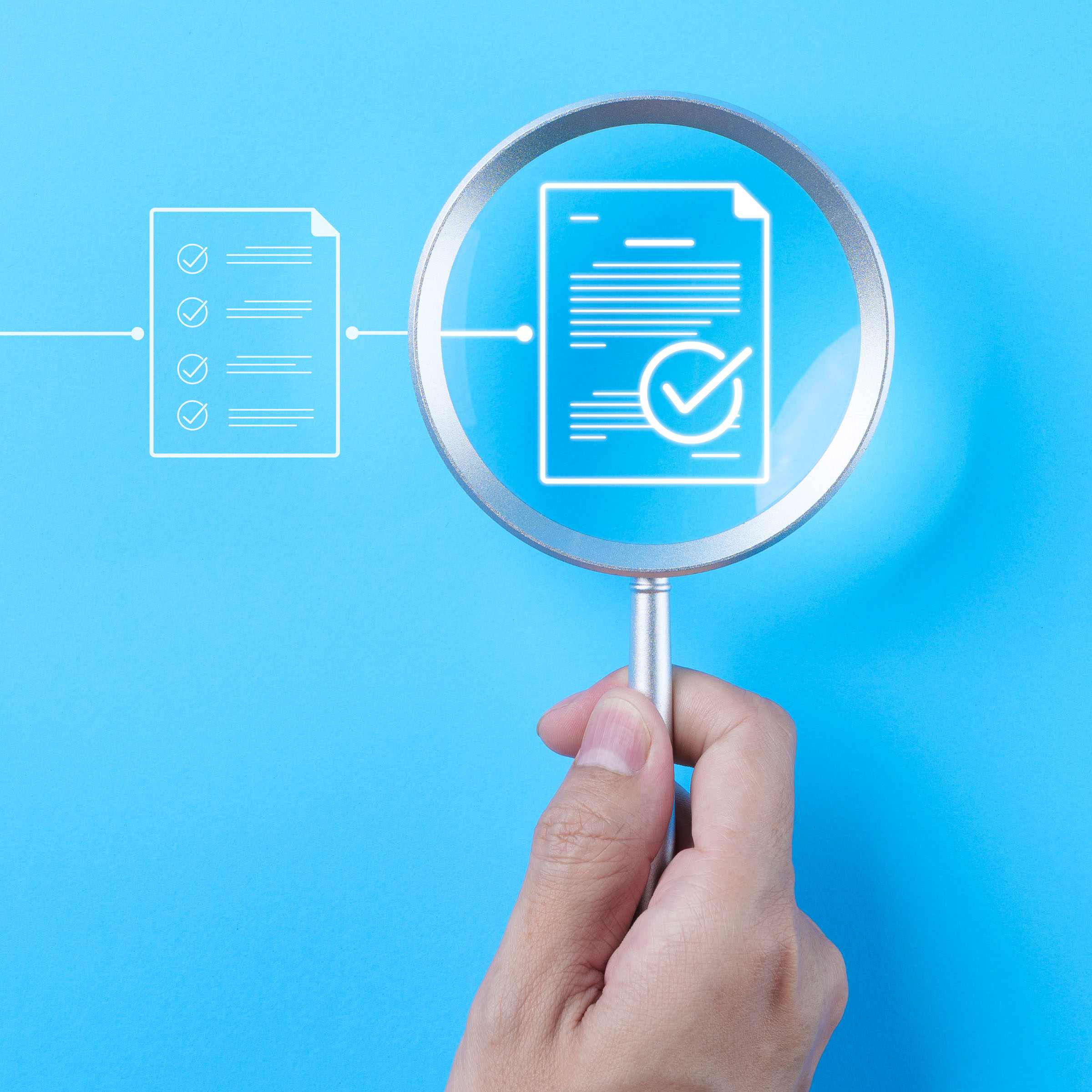 Magnifying glass over digital document symbols as a representation of a review and approval process.