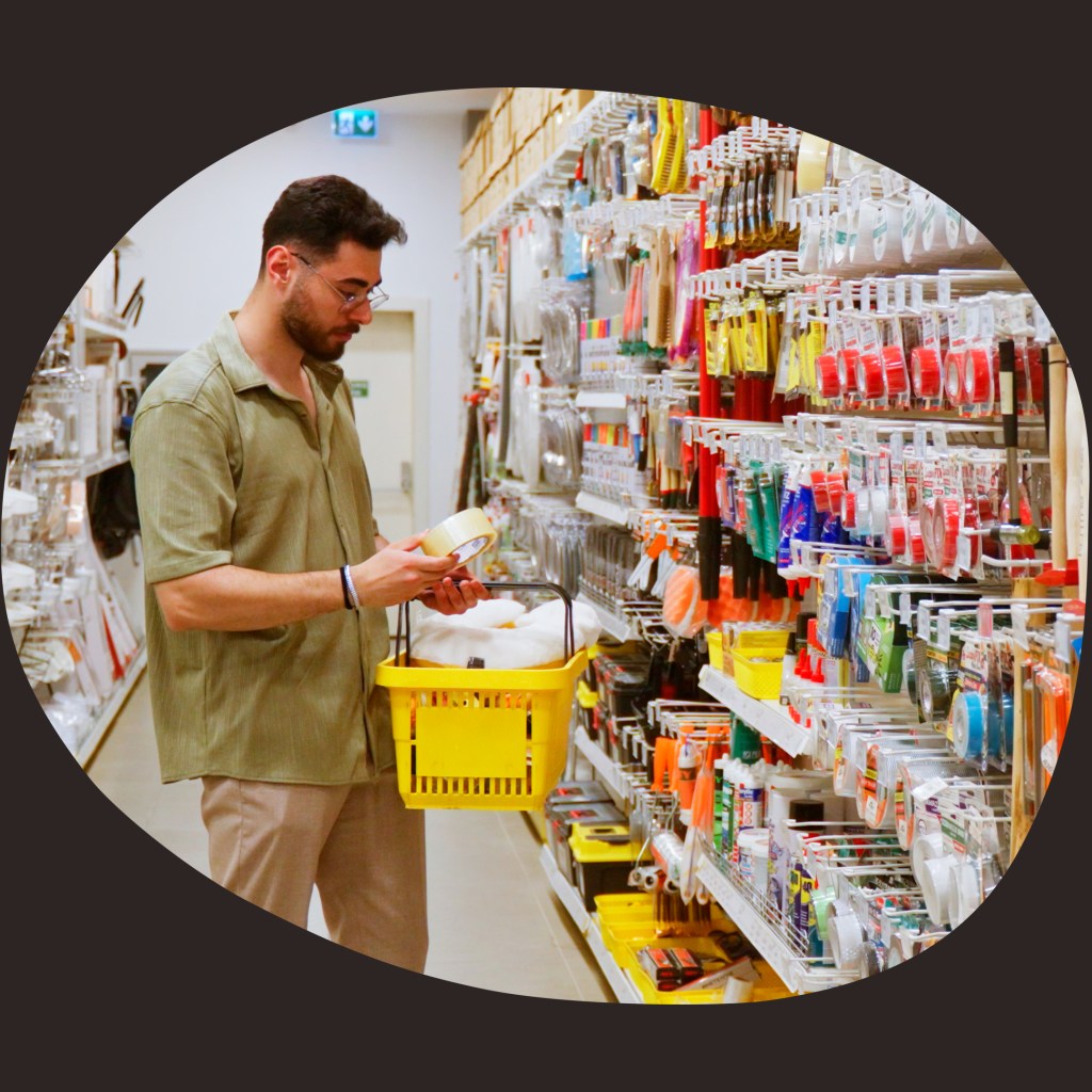 Person betrachtet Produkte in einem Non‑Food‑Einzelhandelsregal.