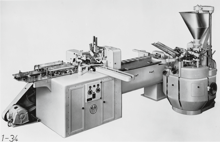 Historic tube filling machine with mechanical assemblies and feeding system.