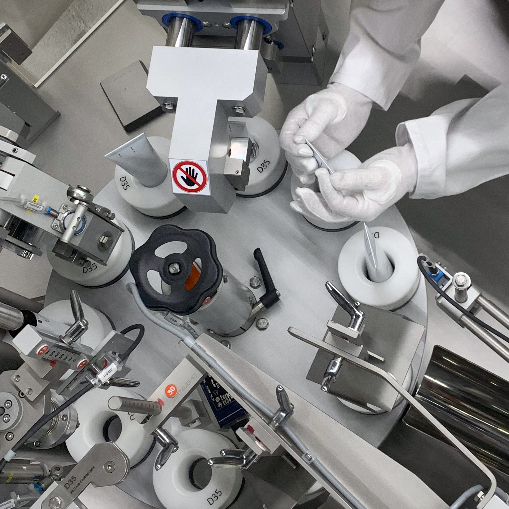 Technical specialist sets up a mechanical module of a tube filling machine.